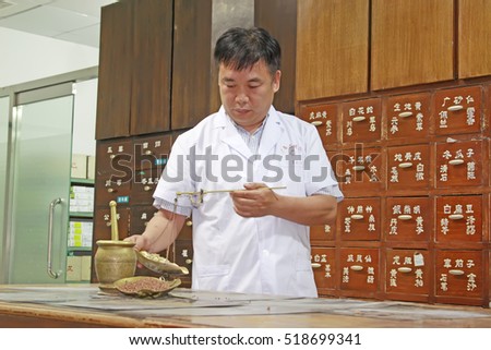 Luannan County - June 18th: a pharmacist weighing Chinese medicinal herbs, June 18th, 2015, Luannan County, Hebei Province, China