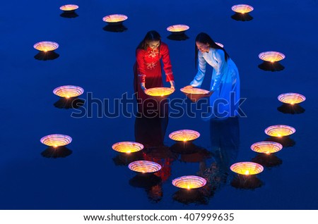 Two Asian beautiful woman putting the Vietnam Hats over the lake at evening twilight time, Countryside Lifestyle concept