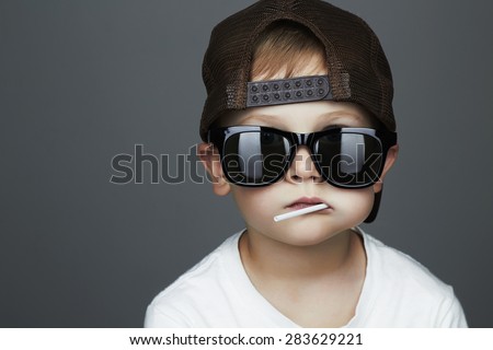 Funny Young Boy Eating A Lollipop.Fashionable child in sunglasses