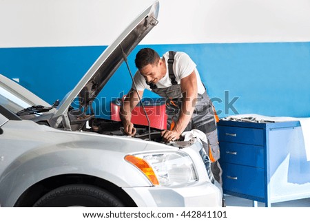 Mechanic repairing a lifted car at garage