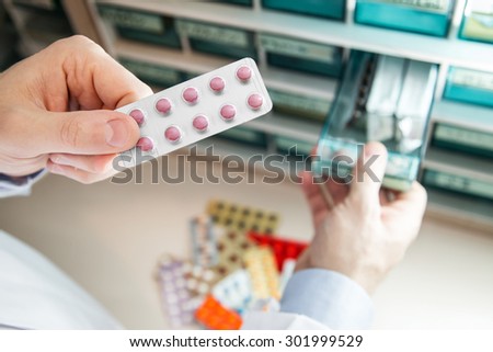 Closeup hands of pharmacist man choosing medicines at pharmacy. Drug store.Medical image.