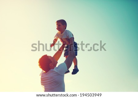 Vintage color photo happy joyful father having fun throws up in the air child, family, travel, vacation, father's day - concept. Sunlight on the sunset