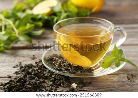 Cup with green tea on grey wooden background