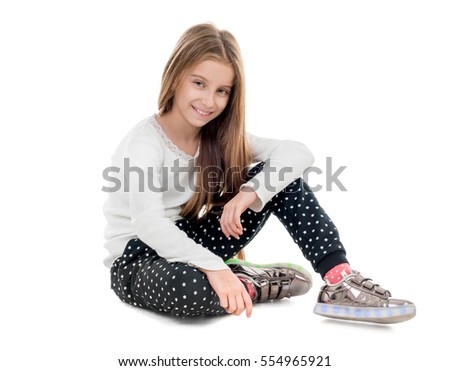smiling teenage girl sitting on the floor, isolated on white background