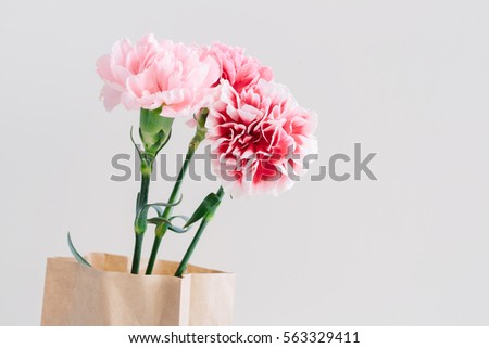 Beautiful bouquet of pink spring flowers in the kraft bag on a light background. Happy International Women's Day, March 8, holiday card.