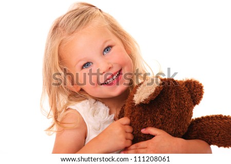 A portrait of a young pretty girl smiling and hugging her teddy bear ...