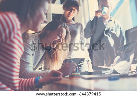 Group of young business people working together in big coworking office. Marketing department discussing product plan. New startup company. Windows reflection effect