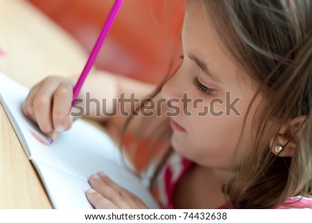 Lovely little girl working in her school project at home