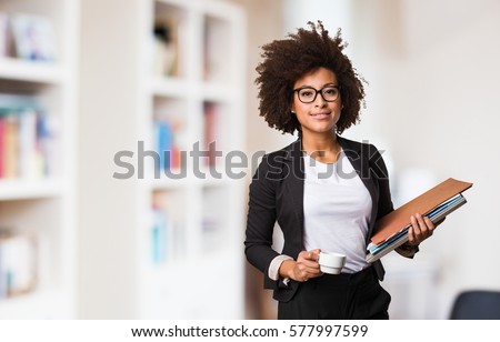 business black woman holding a cup of coffee and files