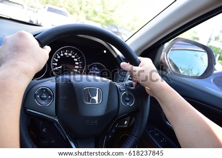 Bangkok, Thailand - April 10, 2017: Man driving car. Honda HRV Black Steering Wheel And Silver Logo. Honda Motor Co., Ltd. is a Japanese public multinational conglomerate corporation.