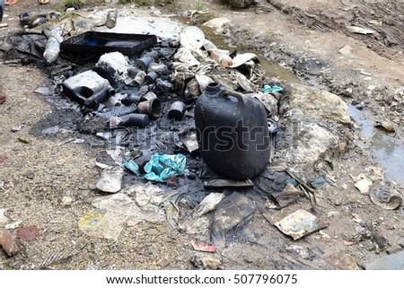 Environmental pollution caused by used engine oil from a workshop by the roadside.