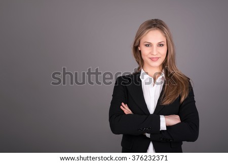 Portrait of wonderful young business woman on gray background with copy space