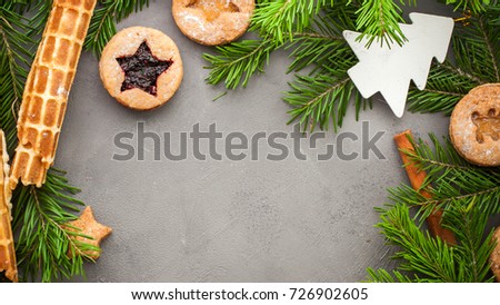 Ginger homemade cookies with strawberry jam on gray concrete background with Christmas tree. View with copy space. Flat lay, top view. Christmas Border -banner.