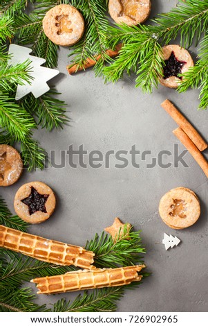 Ginger homemade cookies with strawberry jam on gray concrete background with Christmas tree. View with copy space. Flat lay, top view. Christmas Border -banner.