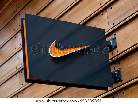 LONDON, UK - JUNE 02, 2017: Nike logo on black display plate on wooden background. Nike, Inc. is an American corporation manufacturing of footwear, apparel, equipment, accessories and services