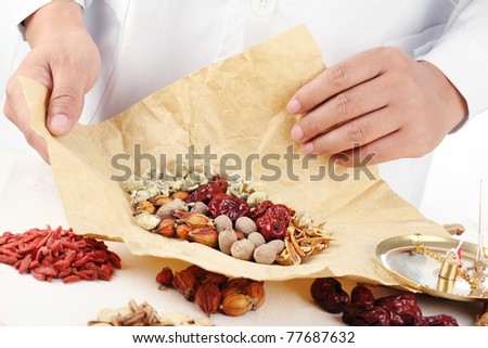 Doctor wrapping Chinese traditional herbal medicine.