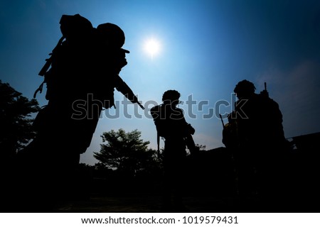 Silhouette of infantry soldiers team with blue sky background