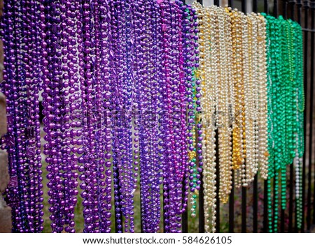 mardi gras beads on fence