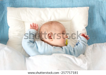Four month old baby sleeping on blue blanket