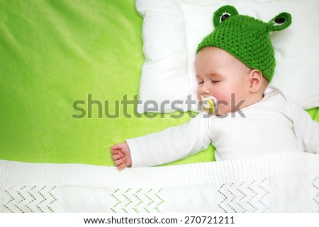 little boy lying on soft green blanket