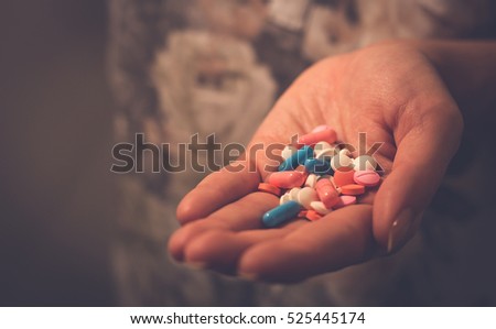female hand holding pills and tablets. sick woman looking for help
