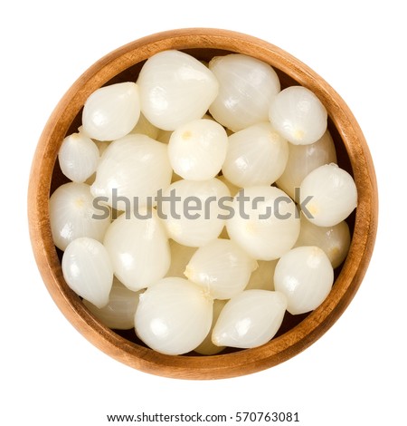 Pickled silverskin onions in wooden bowl. Small white onions pickled in a solution of vinegar and salt, a preserved vegetable. Isolated macro food photo close up from above on white background.