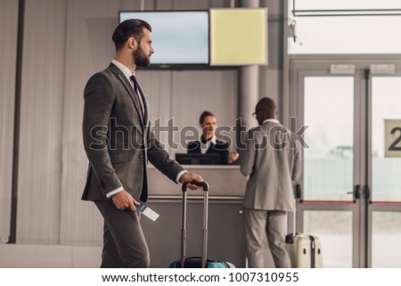 businessman with luggage and flight ticket at airport