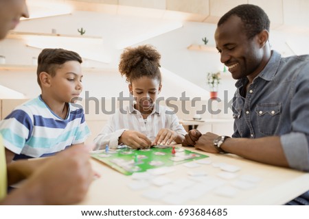 African American Family Playing Board Game In Cafe African American Family Playing Board Game In Cafe