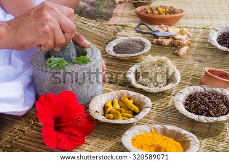 A young man preparing ayurvedic medicine in the traditional manner in India