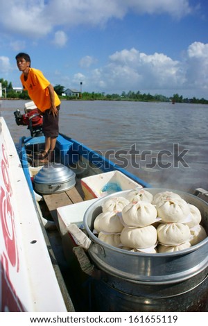 CA MAU, VIET NAM- JUNE 29: Food vendor by boat selling dumpling on water, this is culture of mekong delta, Ca Mau, Viet Nam, June 29, 2013