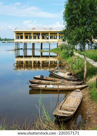 DONG THAP, VIET NAM- SEPT 19: Landscape of Vietnamese shool in flooded season, shool reflect on water, group of row boat floating on river, vehicle of waterway Mekong Delta, Vietnam, Sept 19, 2014