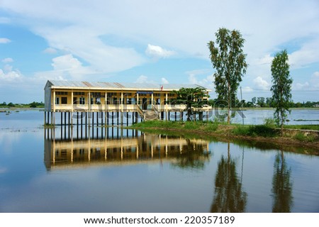 DONG THAP, VIET NAM- SEPT 19: Landscape of Vietnamese shool in flooded season, shool reflect on water, group of row boat floating on river, vehicle of waterway Mekong Delta, Vietnam, Sept 19, 2014