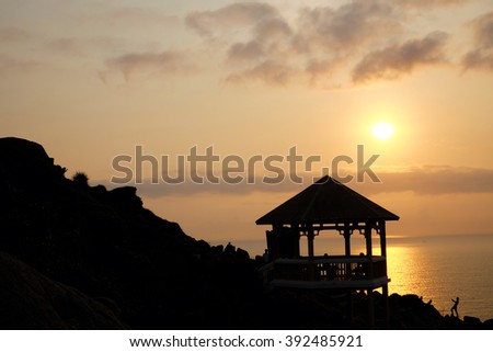 Silhouette of watch tower and people in morning at Dai Lanh cape, Mui Dien, Phu Yen, Viet Nam, yellow sun in sunrise make beautiful scene, this place catch the first sunlight in Vietnam country
