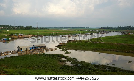 DONG NAI, VIET NAM- JUNE 5: Group of floating house on La Nga fishing village, river with green grass and hyacinth, residence of people who live with fish farming at Dongnai, Vietnam