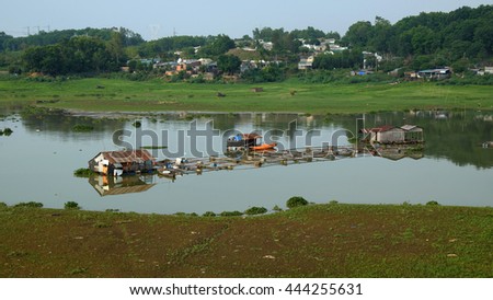 DONG NAI, VIET NAM- JUNE 5: Group of floating house on La Nga fishing village, river with green grass and hyacinth, residence of people who live with fish farming at Dongnai, Vietnam