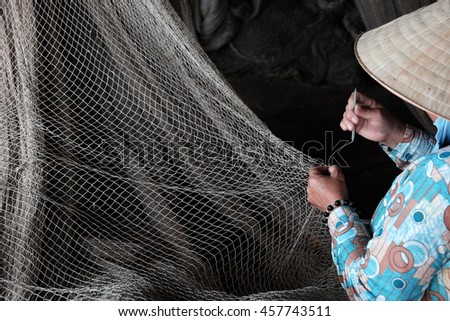 Vietnamese woman sewing fishing net at Ca Mau,Vietnam