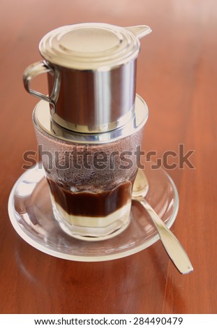 'Phin' traditional Vietnamese coffee maker, place on the top of glass, add ground coffee then pour hot water and wait until the coffee dripping into the glass with condensed milk at the bottom