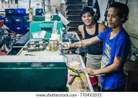 KANCHANABURI, THAILAND - JULY 22, 2017: Burmese Male Migrant Workers Cutting or Stitching Leather Shoes with Machine in Footwear Production Line of Factory in Sankhlaburi, Kanchanaburi, Myanmar Border