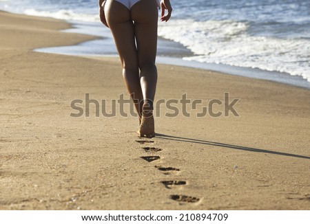 https://thumb7.shutterstock.com/display_pic_with_logo/1797308/210894709/stock-photo-young-woman-walking-alone-on-the-sand-beach-in-the-sunset-and-leave-footprints-behind-focus-on-the-210894709.jpg