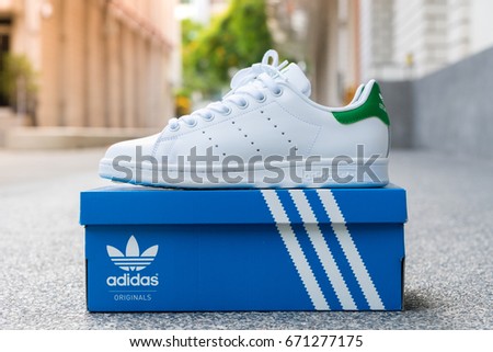 BANGKOK, THAILAND - JULY 2, 2017: Open box adidas stan smith classic shoes on ground stone outdoor popular fashion thailand.