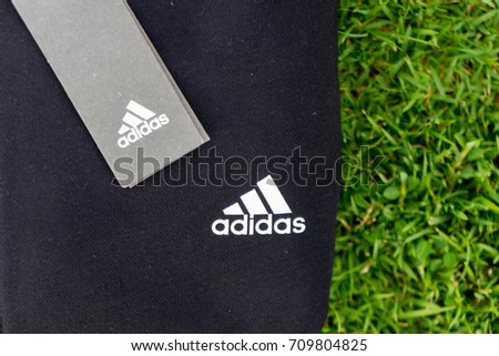 NAKHON PATHOM, THAILAND - SEPTEMBER 2, 2017:A logo adidas on sports jacket and sweatpants, A German multinational corporation that designs and manufactures sports shoes, clothing and accessories