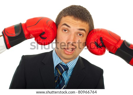 Business man being kicked by two boxing gloves and making a face ...