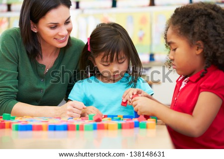 Elementary Pupils Counting With Teacher In Classroom