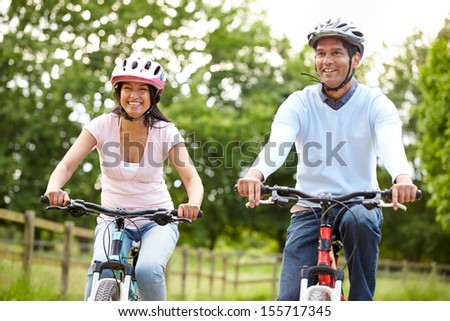 Indian Couple On Cycle Ride In Countryside