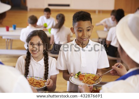 Over shoulder view of kids being served in school cafeteria Over shoulder view of kids being served in school cafeteria