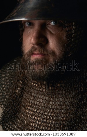 Portrait of a medieval infantry man wearing his elm and chainmail. Historical reenactment portrait in a flemish painting style