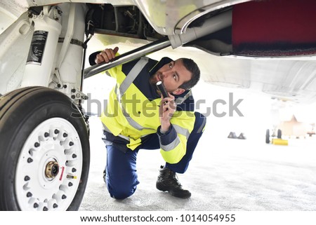 Ground personnel at the airport check the hydraulic system of the landing gear of the aircraft