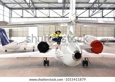 Airport workers check an aircraft for safety in a hangar