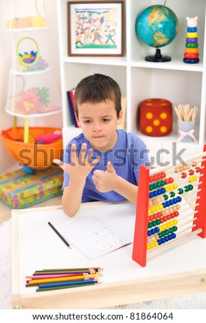 Little boy preparing for elementary school doing simple math exercises ...