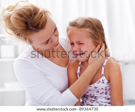 Mother comforting her crying little girl - parenthood concept
